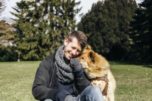 Happy man playing with Eurasier in park